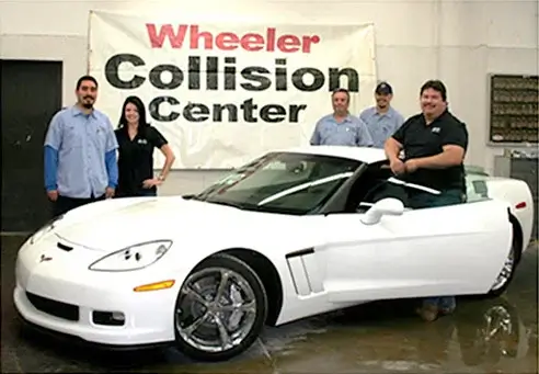 picture of people standing by a mazda car in the wheeler collision center